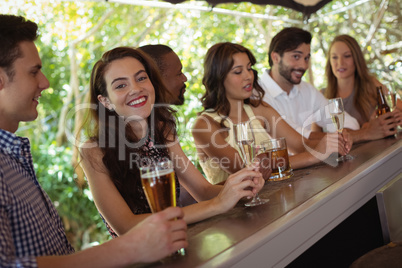 Friends interacting while having a alcohol at counter