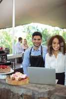 Male waiter and female waitress with laptop