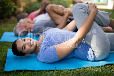 Portrait of smiling trainer exercising while lying down