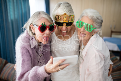 Senior women wearing novelty glasses making face while taking selfie