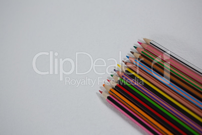 Various color pencils arranged on white background