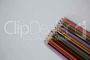 Various color pencils arranged on white background