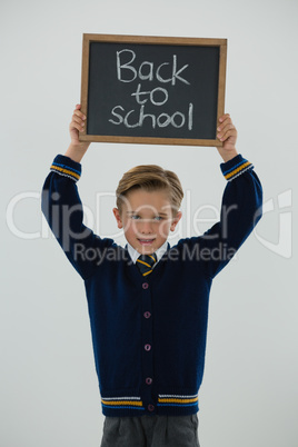 Schoolboy holding slate with text against white background