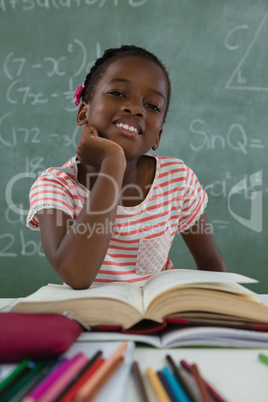 Schoolgirl reading book in classroom