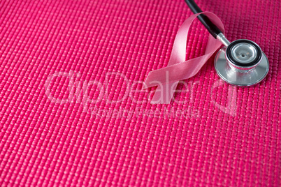 High angle view of stethoscope by pink Breast Cancer Awareness ribbon