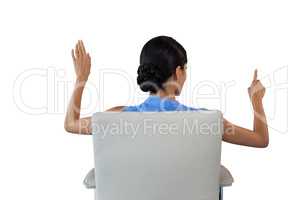 Rear view of businesswoman touching interface white sitting on chair