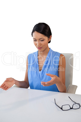 Young businesswoman gesturing while sitting at table