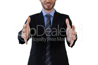 Mid section of smiling businessman in suit marketing invisible product