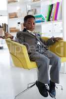 Full length portrait of businessman sitting on armchair