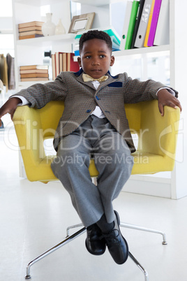 Businessman looking away while sitting on armchair