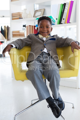 Portrait of smiling businessman sitting on armchair