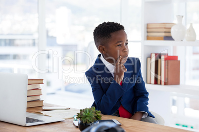 Thoughtful businessman with hand on chin looking away