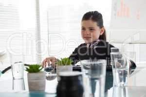 Smiling businesswoman looking away while sitting at desk