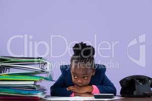 Bored businesswoman leaning by files and telephone on desk