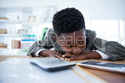 Bored businessman leaning on desk while looking away