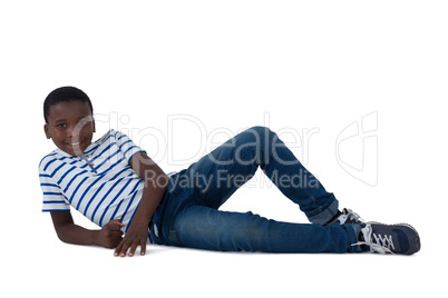 Boy lying on floor against white background