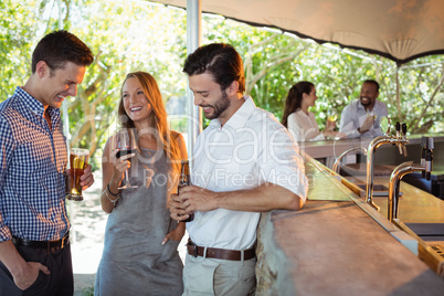 Friends interacting while having a alcohol at counter