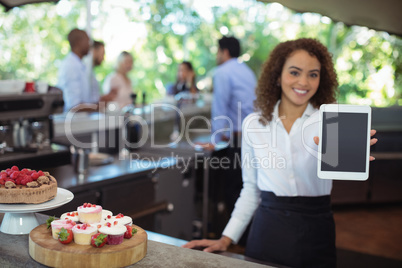 Waitress showing digital tablet at outdoor cafÃ?Â©