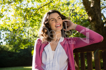 Woman sitting on bench and talking on mobile phone