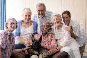 Portrait of smiling doctor and senior friends with dog