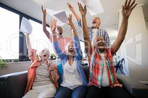 Excited senior people with arms raised throwing papers