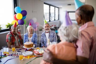 Smiling friends looking at senior couple during party