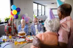 Smiling friends looking at senior couple during party