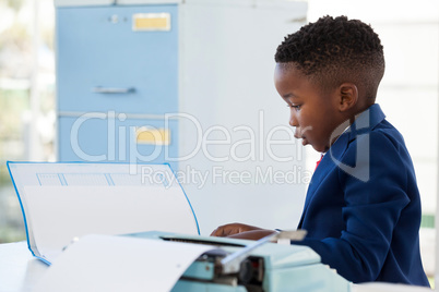 Side view of businessman reading document while working