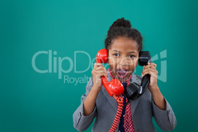 Portrait of surprised businesswoman talking land line phones