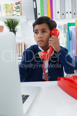 Businessman looking away while using landline phone