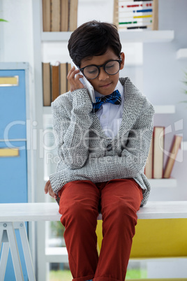 Businessman using smart phone while sitting on desk