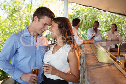 Couple having a glass of beer at counter in restaurant