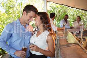 Couple having a glass of beer at counter in restaurant