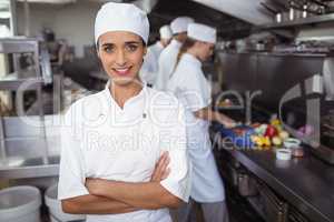 Portrait of kitchen staff standing with arms crossed