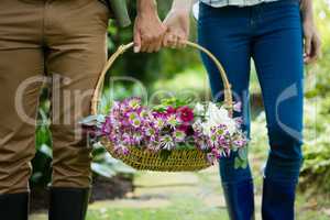 Mid-section of couple walking with flower basket