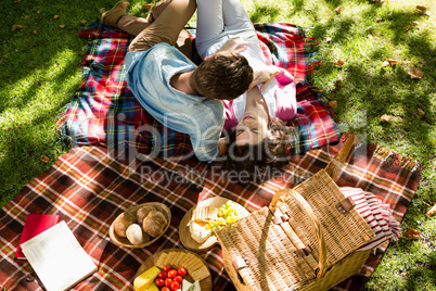 Romantic couple lying on picnic blanket in park