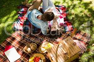 Romantic couple lying on picnic blanket in park