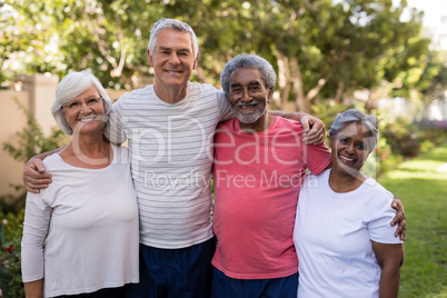 Portrait of smiling friends standing with arms around