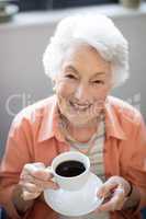 High angle portrait of senior woman holding coffee cup
