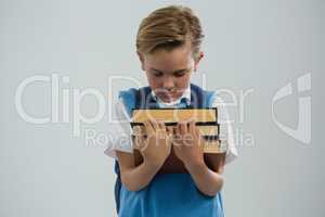 Schoolboy holding books against white background
