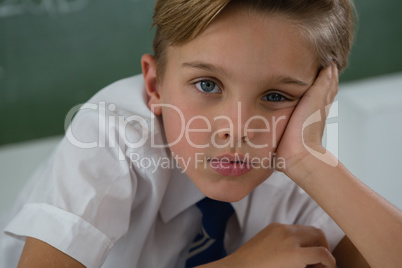 Schoolboy relaxing in classroom