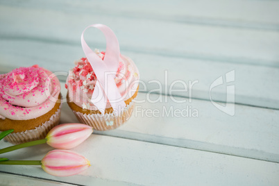 High angle view of Breast Cancer Awareness pink ribbons on cupcakes with tulips