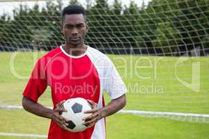 Portrait of serious confident male soccer player holding ball