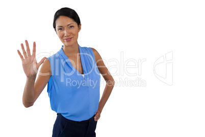 Smiling businesswoman touching interface while standing with hand on hip
