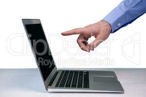 Cropped hand of businessman pointing on laptop computer