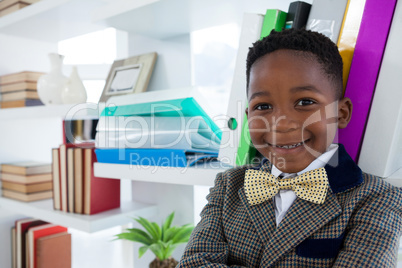 Close up portrait of smiling boy imitating as businessman