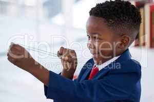 Side view of boy playing with rubber band