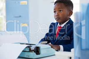 Businessman looking away while sitting at desk