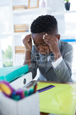 Businessman with head in hand sitting at desk