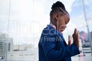 Businesswoman with closed eyes standing at window